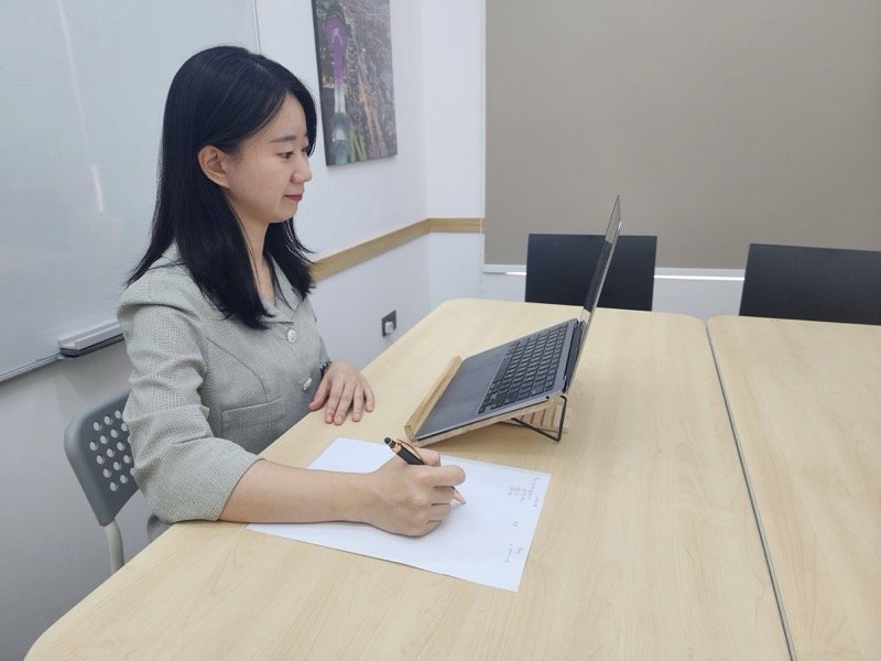 Woman taking notes during online class
