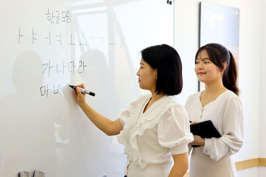 iSeodang teachers writing Hangul on the whiteboard