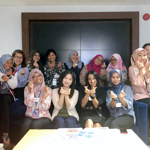 Employees making finger hearts after a corporate Korean class by iSeodang